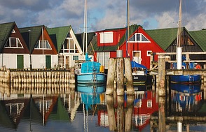 Schmucke Bootshäuser am Hafen laden ...